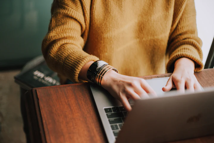 Founder typing on a laptop at a wooden desk