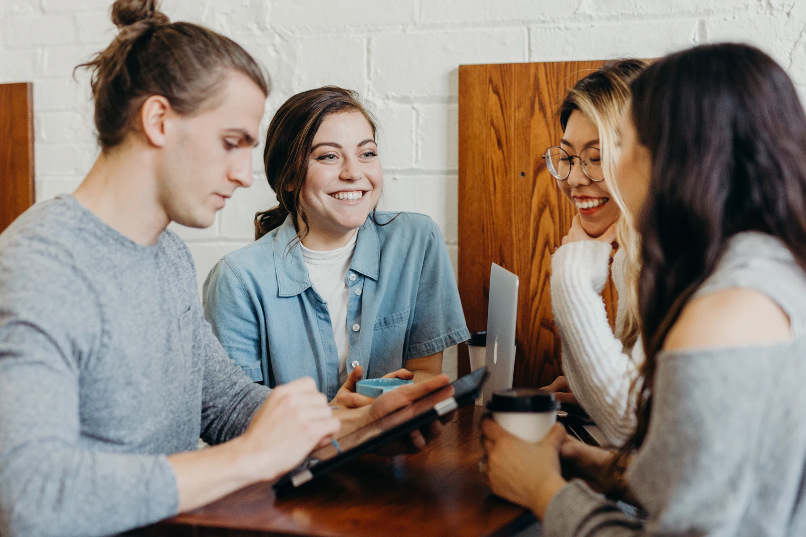 Startup team laughing together around a laptop